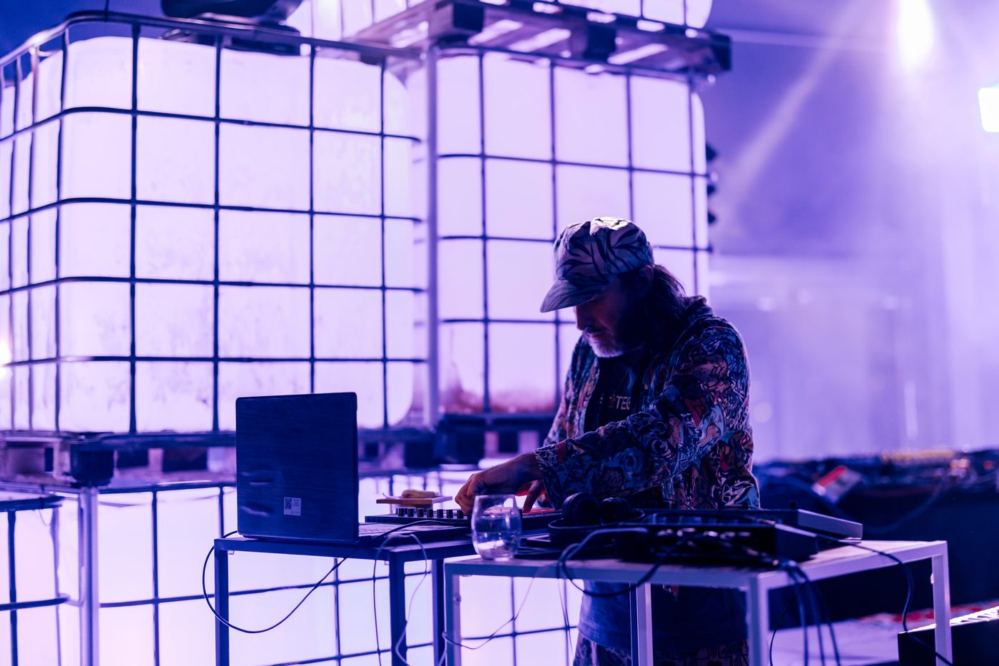 Alaska at the synth station in front of the glowing cube wall