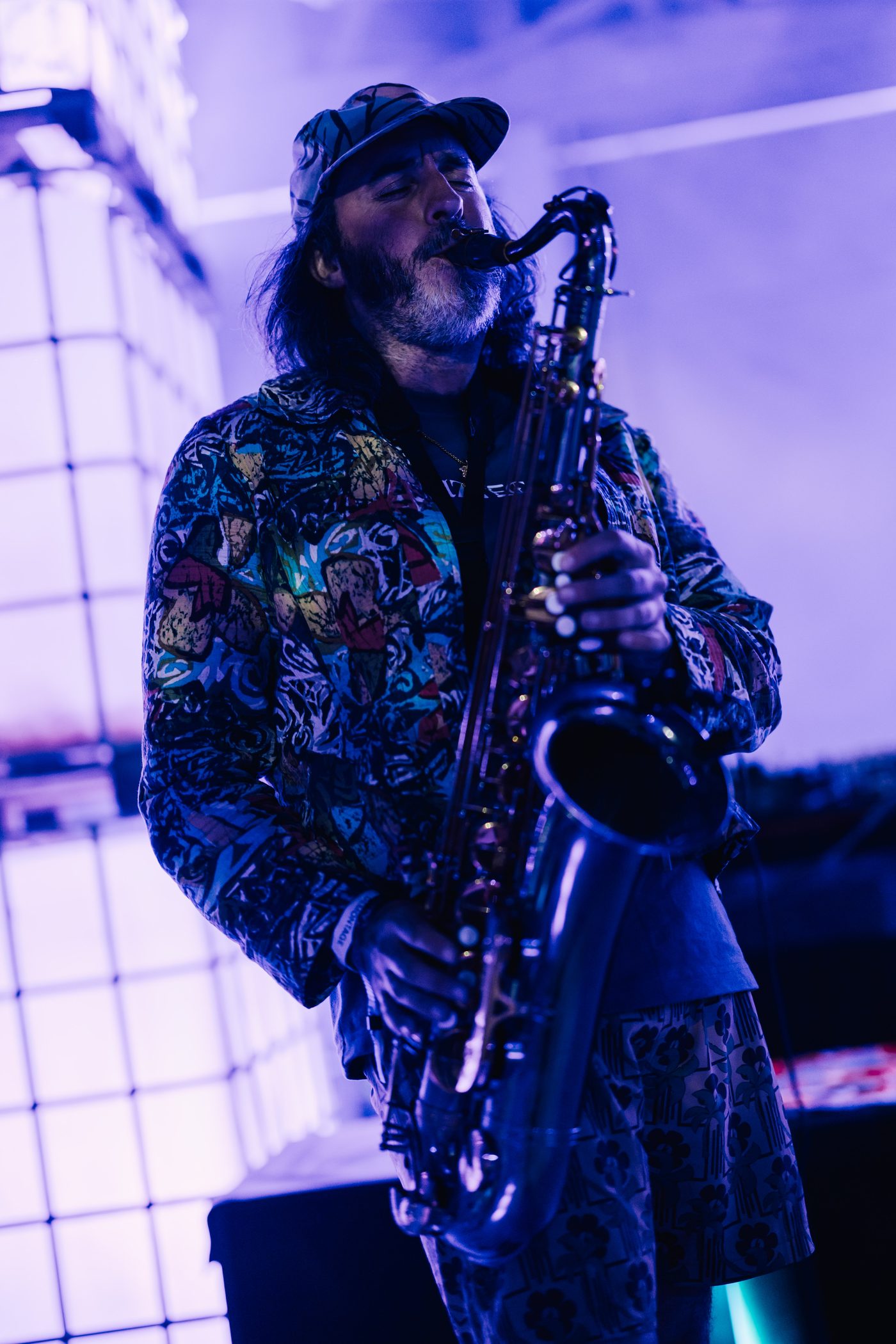 Saxophonist in a butterfly jacket under blue light