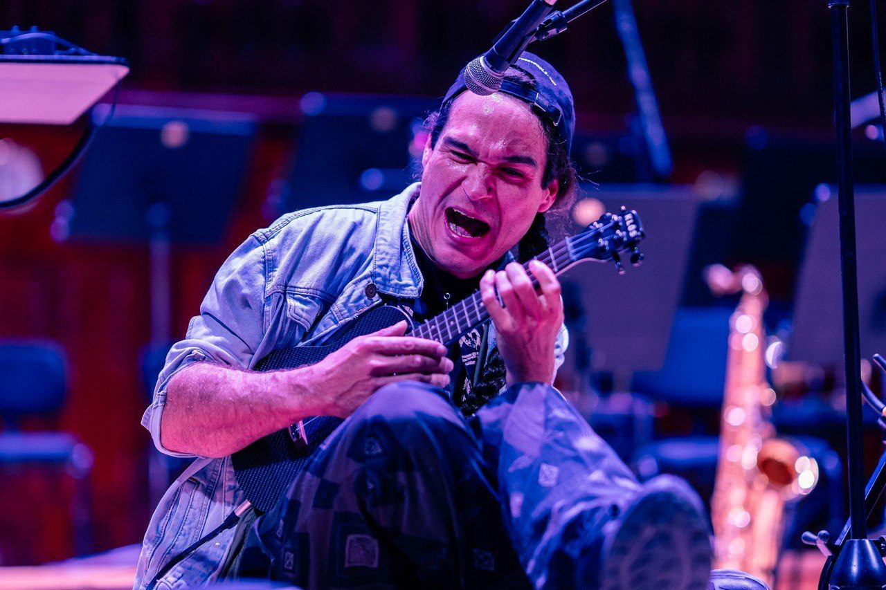 Shaka lost in the music, playing guitar under purple stage light